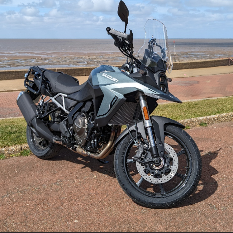 A green Suzuki 800RE motorcycle by the sea